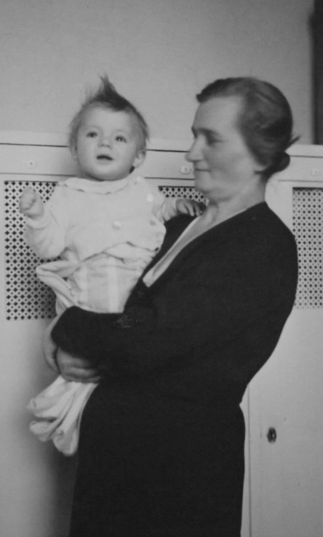 Jiří Pitín as a child, held by a woman in a historical family photograph.