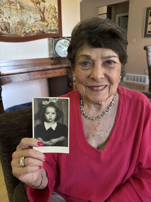 Agi Day holding a photograph of herself as a child.