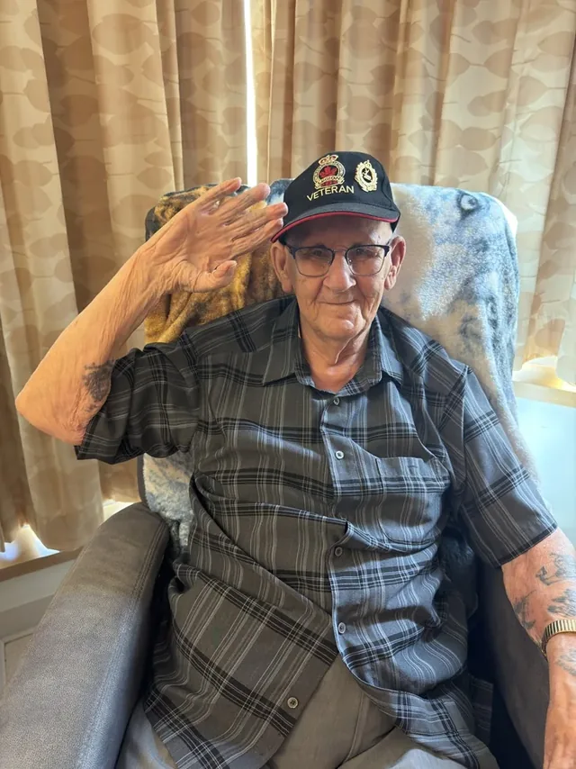 Alfred Cormier saluting while wearing his veteran’s cap.