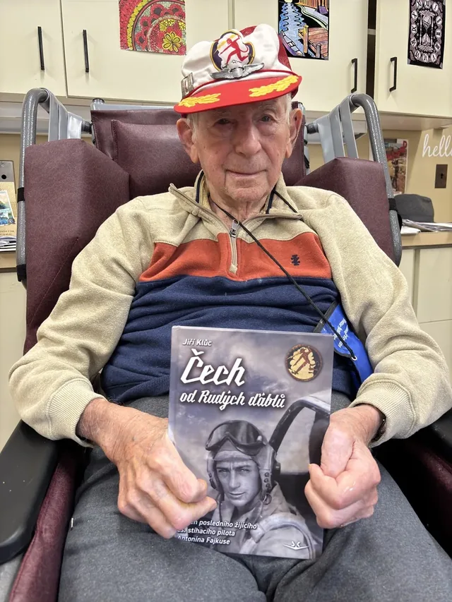 Antonín Fajkus holding Jiri Kluc’s book about his life.