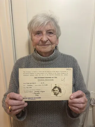 Eva Paddock holding her childhood travel document.