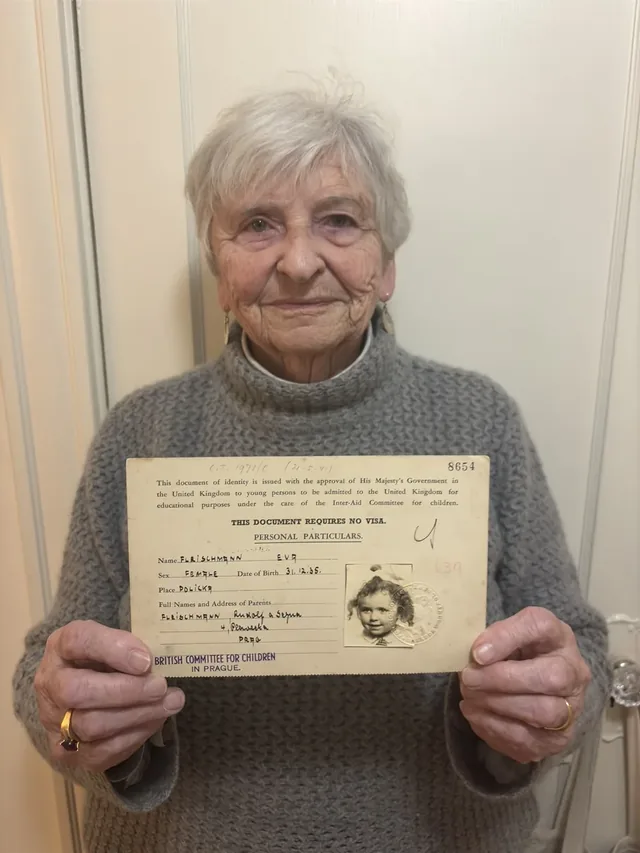 Eva Paddock holding her childhood travel document.