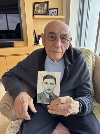 Jack Waksal holding a photograph of himself as a young man.