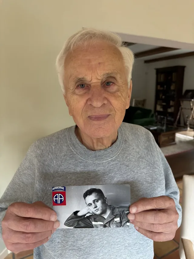 Josef Mašín holding a photograph from his United States Army service.