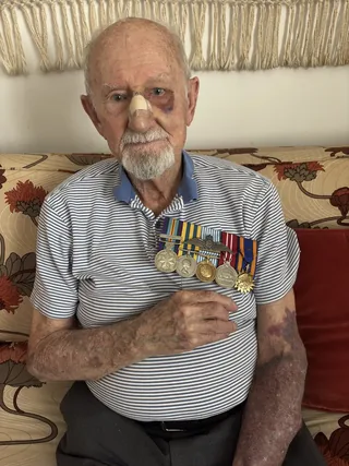 Spencer Seaver holding his military medals.