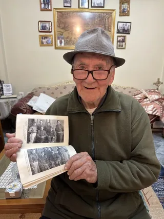 Stillo Papadhima holding a photo album.