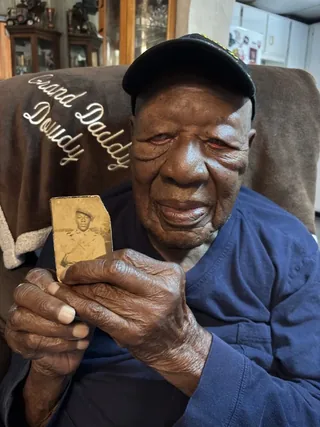 Thomas Dowdy holding his wartime photograph.